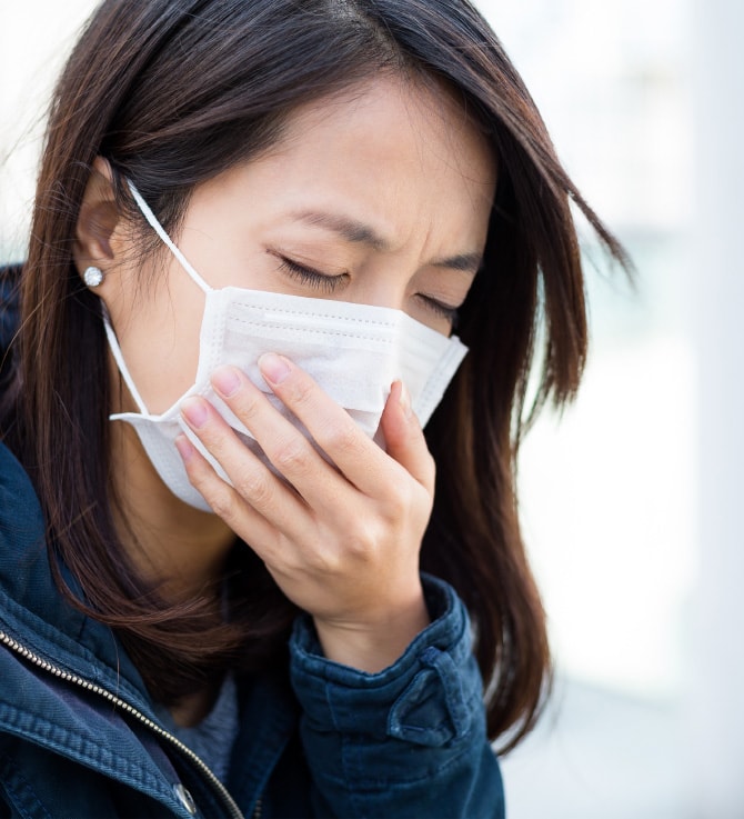 口を押さえ苦しそうなマスクをした女性