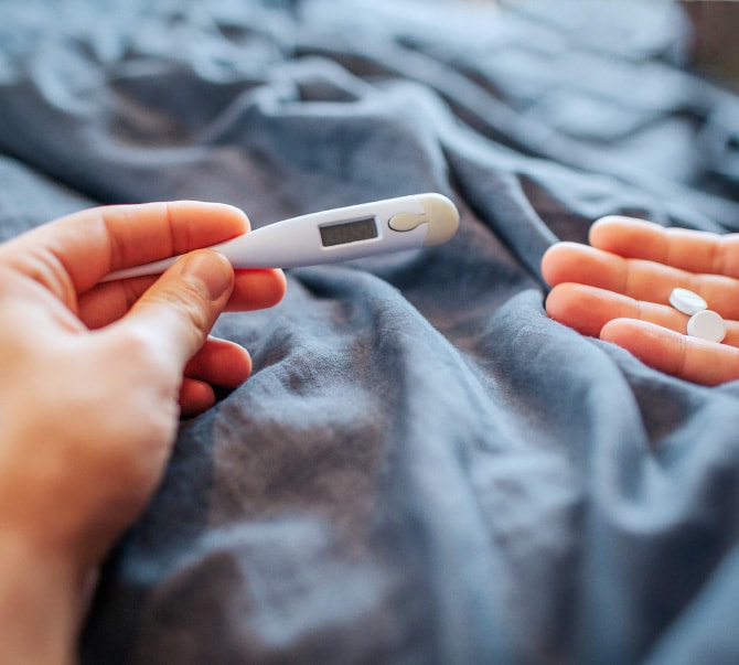薬を手に体温計を見る様子
