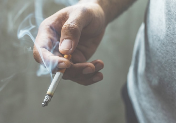 火の付いたタバコを手に持つ様子